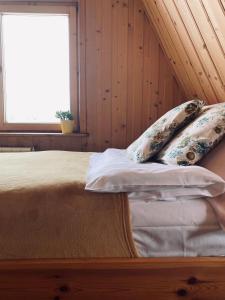 a bedroom with a bed with pillows and a window at U Haliny - Blisko Term & Gorącego Potoku in Szaflary