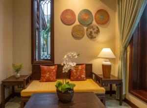 salon z kanapą i talerzami na ścianie w obiekcie Cozy Savvy Boutique Hotel Hoi An w Hoi An