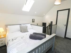 a bedroom with a large white bed with a window at Owl Cottage in Pwllheli