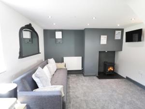 a living room with a couch and a fire place at Owl Cottage in Pwllheli