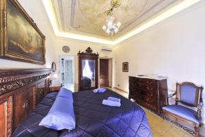 a bedroom with a large blue bed and a chair at Central Domus Roma in Rome
