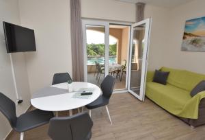 a living room with a table and a green couch at Apartment Aurea in Primošten