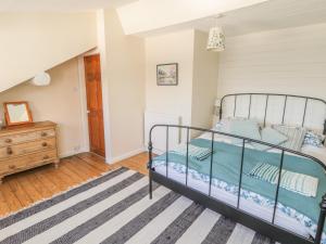 Schlafzimmer mit einem Bett und Holzboden in der Unterkunft Salmon Cottage in Saltburn-by-the-Sea