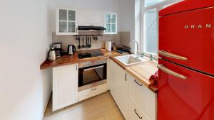 uma cozinha com um frigorífico vermelho e um lavatório em Ihr Zuhause am Jakobikirchhof em Goslar