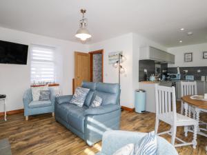 a living room with a blue couch and a kitchen at Wee Wickie in Lossiemouth