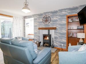 a living room with a blue couch and a fireplace at Wee Wickie in Lossiemouth