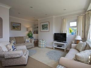 ein Wohnzimmer mit Sofas und einem Flachbildfernseher in der Unterkunft Moonrakers, Clarence Street in Dartmouth