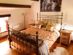 1 dormitorio con 1 cama grande y suelo de madera en The Stables en Settle