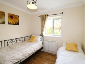 two beds in a room with a window at Barforth Hall Lodge in Richmond