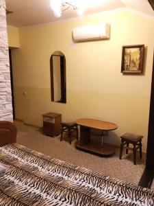 een kamer met een bed, een tafel en een spiegel bij Hotel u Olega in Truskavets