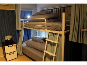 a bunk bed with two mattresses on it in a room at Shiroyama Guesthouse Banvina in Kagoshima