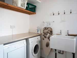 eine Waschküche mit einer Waschmaschine und einem Waschbecken in der Unterkunft 29 Fore Street in Salcombe