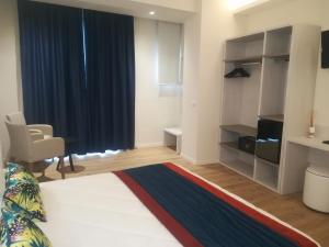 Zimmer mit einem Bett, einem Stuhl und einem Fenster in der Unterkunft Roma Hotel in Castiglione della Pescaia