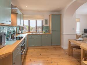 希望海灣的住宿－2 Armada House，铺有木地板的厨房配有绿色橱柜