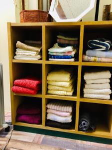 ein Regal mit Handtüchern und Handtüchern in der Unterkunft うたかたの宿 in Himeji