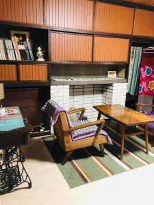 ein Wohnzimmer mit einem Tisch und einem Kamin in der Unterkunft うたかたの宿 in Himeji