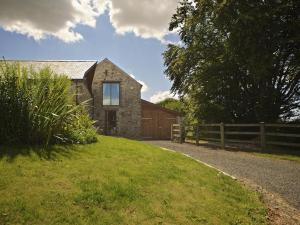 a brick house with a fence next to a road at Meadow View in Ivybridge