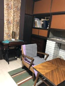 a room with a table and a chair and a desk at うたかたの宿 in Himeji