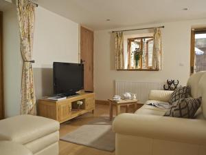 a living room with a couch and a flat screen tv at Meadow View in Ivybridge