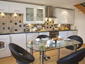 a kitchen with a glass table and chairs in it at Meadow View in Ivybridge