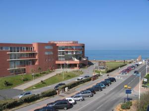 Un estacionamiento con autos estacionados frente a un edificio. en Appartement Pour 4 Personnes Avec Vue Sur L ocean- Residence Le Signal, en Capbreton