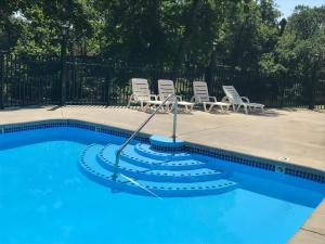 a swimming pool with chairs and a hose in the water at The River Cottage in Pigeon Forge