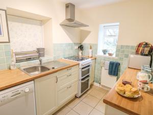 a kitchen with a sink and a stove top oven at Barn Croft Cottage in Matlock +10 photos