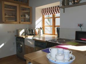 uma cozinha com uma mesa com canecas em Mill House Barn em Okehampton
