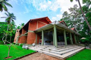 un complexe avec un bâtiment en briques rouges et une terrasse couverte dans l'établissement Arika Villa, à Dambulla