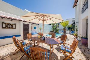 a wooden table and chairs with an umbrella on a patio at Big Blue Accommodation in Bloubergstrand