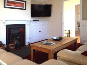 a living room with a table and a fireplace at Hedgelea in Winkleigh