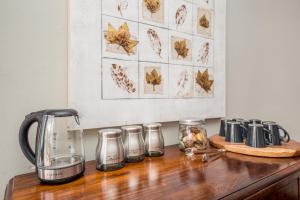 eine Theke mit einer Kaffeemaschine auf einem Holztisch in der Unterkunft Big Blue Accommodation in Bloubergstrand