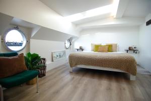 sypialnia z łóżkiem i zielonym krzesłem w obiekcie Eco HouseBoat w Amsterdamie