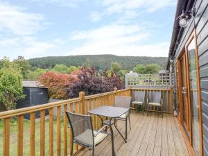 a balcony with a table and chairs on a deck at The Bungalow in Corwen