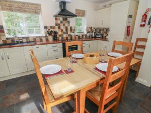 a kitchen with a wooden table and chairs at Eskholme Lodge in Ravenglass