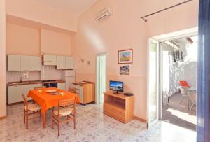 una cucina e una sala da pranzo con tavolo e sedie di Casa Vacanze Parco Del Generale a Ischia