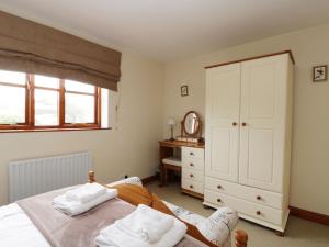 a bedroom with a bed and a dresser and a mirror at Eskview Cottage in Whitby