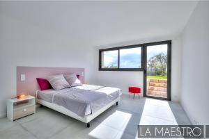 a white bedroom with a bed and a window at Domaine du Peyrouas in Saint-Jeannet +21 photos