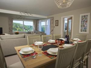 Un comedor con una mesa con platos y copas de vino. en 2 Hamstone Court, en Salcombe