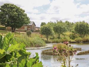 een tuin met een rivier en bloemen op de voorgrond bij Beech Cottage in Truro