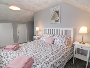 una camera da letto con un letto grande con due tavoli e due lampade di Buarthau Cottage a Caernarfon