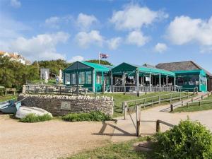 a building with green roofs and tables in a field at Lilac Cottage in Burton Bradstock