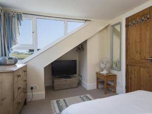 um quarto com uma escada com uma televisão e uma cama em Shipwrights em Salcombe