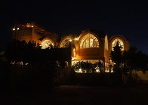 a large building at night with its lights on at Malkata House in Luxor