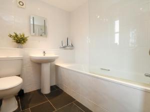 a bathroom with a sink and a toilet and a bath tub at Hawthorn Cottage in Truro +18 photos