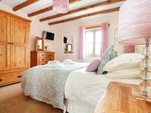 a bedroom with a bed and a table at Hawthorn Cottage in Truro