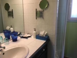 ein Bad mit einem Waschbecken und einem Spiegel in der Unterkunft Le Relais des Malettes Chambres d'hôtes B&B in Francheville