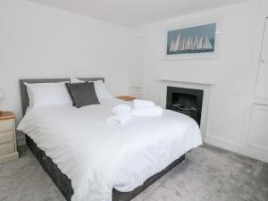 a white bed in a room with a fireplace at Apartment 2 22 Foss Street in Dartmouth