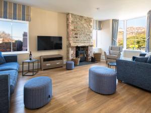 a living room with blue furniture and a fireplace at May Cottage in Kingsbridge