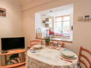 a dining room with a table and a television at Church Road Annexe in Cinderford